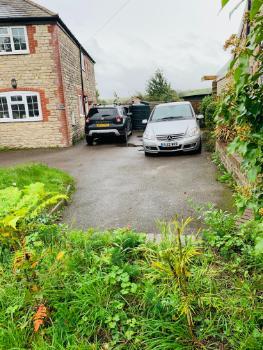 enclosed front bay of parking beside cottage